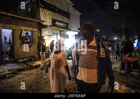 Les résidents rentrent chez eux tard dans la soirée en passant par les rues animées du bidonville de Kibera, Nairobi. Kibera, le plus grand bidonville de Nairobi et d'Afrique, abrite Banque D'Images