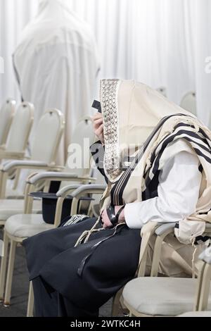 Un homme juif hassidique pieux portant un tallis & Tefillin prie dans une synagogue du comté de Rockland, Neew York. Banque D'Images