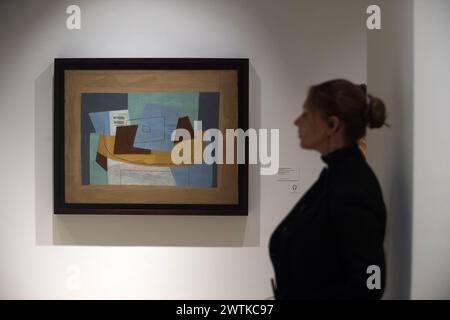 Malaga, Espagne. 18 mars 2024. Un ouvrier se tient à côté d'un tableau 'Partitura musical y guitarra' lors de l'inauguration du 'Pablo Picasso : structure de l'invention. L’unité d’une œuvre » exposition au Musée Malaga Picasso. La nouvelle collection, qui sera conservée dans le musée jusqu’en 2027, présente environ 150 œuvres de l’artiste espagnol Pablo Picasso (1881-1973) et 10 d’entre elles seront exposées dans le pays pour la première fois. Crédit : SOPA images Limited/Alamy Live News Banque D'Images