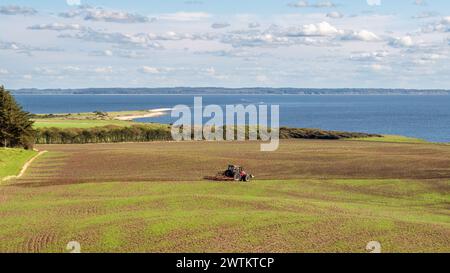 Côte sud-est de l'île de Livø dans le Limfjord avec tracteur dans les champs agricoles, Nordjylland, Danemark Banque D'Images