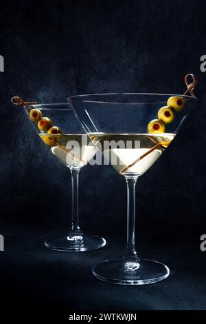 Martini. Deux verres de cocktails martini sales avec vermouth et olives, vue latérale avec espace photocopie Banque D'Images