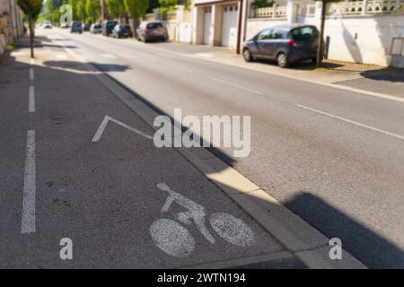 Voie réservée aux bicyclettes, séparée de la circulation des véhicules par une ligne marquée sur le côté d'une rue de la ville. Banque D'Images