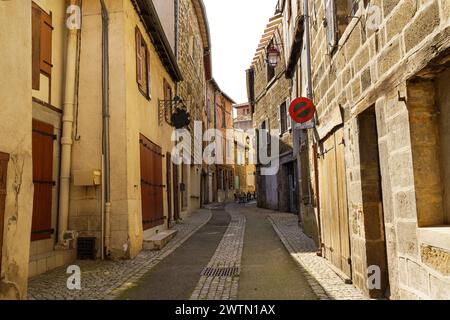 Une rue étroite avec un panneau d'arrêt positionné au milieu de celui-ci, créant un point de pause pour les véhicules voyageant à travers la zone urbaine. Banque D'Images