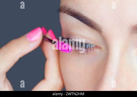 Belle Femme avec de longs cils en institut de beauté. Procédure d'extension de cils. Lashes close up Banque D'Images