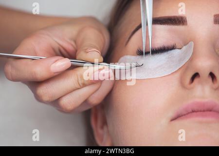 Procédure de dépose de cils close up. Belle Femme avec de longs cils en institut de beauté. Extension de cils. Banque D'Images