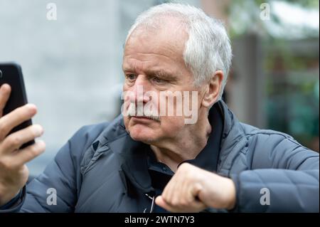 Homme senior regardant confus au téléphone portable. Banque D'Images