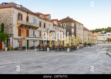 Place principale Pjaca dans la vieille ville médiévale de Hvar avec des restaurants en plein air et café de promenade latérale au lever du soleil avec personne, Dalmatie, Croatie. Voyages populaires et Banque D'Images