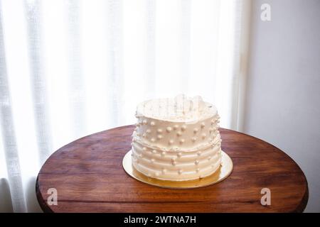 Gâteau de fête blanc avec glaçage blanc et perles, conception de gâteau. Gâteau fait à la main fait pour une occasion spéciale de célébration. Copier l'espace Banque D'Images