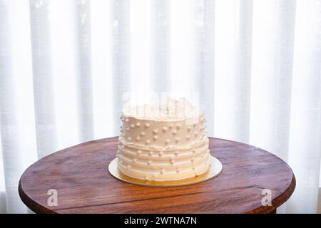 Gâteau de fête blanc avec glaçage blanc et perles, conception de gâteau. Gâteau fait à la main fait pour une occasion spéciale de célébration. Copier l'espace Banque D'Images