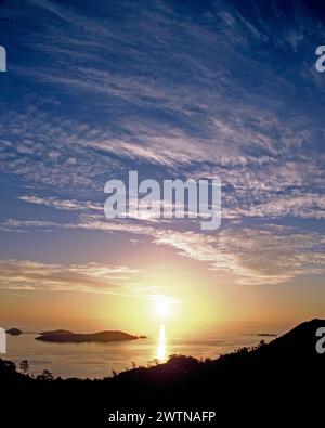 Seychelles. Mahé. Lever de soleil sur la côte avec Cerf Island. Banque D'Images