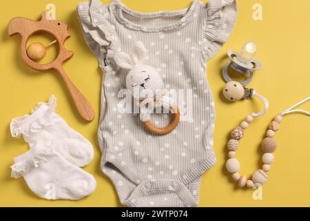 Différents accessoires de bébé sur fond jaune, plat Banque D'Images