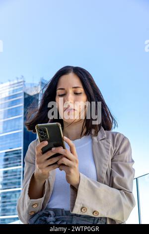 Vue en bas angle d'une belle femme écrivant un message sur son smartphone. Copier l'espace. Banque D'Images