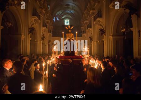 Malaga, Espagne. 18 mars 2024. La statue du Christ est portée par des pénitents de la confrérie 'Humildad' alors qu'ils participent au transfert du cloître de la statue du Christ à son char dans l'église Santuario de la Victoria, avant le début de la semaine Sainte le dimanche des Rameaux. Au cours des dernières semaines, des dizaines de confréries portent leurs icônes dans leurs églises, suivant les rituels traditionnels entourés par la lumière des bougies. (Photo de Jesus Merida/SOPA images/SIPA USA) crédit : SIPA USA/Alamy Live News Banque D'Images