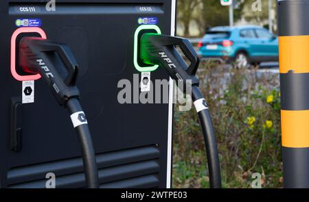 Laatzen, Allemagne. 19 mars 2024. Deux câbles de recharge suspendus à une station de recharge rapide pour voitures électriques dans la région de Hanovre. La suppression de la prime à l'achat de voitures électriques en Allemagne à la fin de 2023 a provoqué un effondrement de la demande de voitures électriques. Crédit : Julian Stratenschulte/dpa/Alamy Live News Banque D'Images