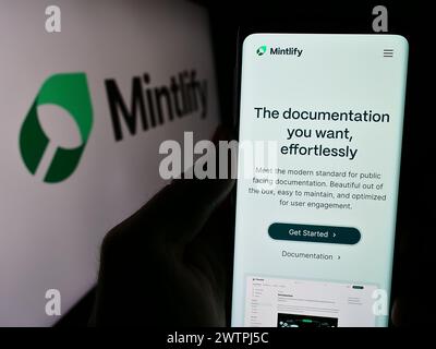 Personne tenant le téléphone portable avec la page Web de la société de plate-forme de documentation américaine Mintlify Inc devant le logo. Concentrez-vous sur le centre de l'écran du téléphone. Banque D'Images