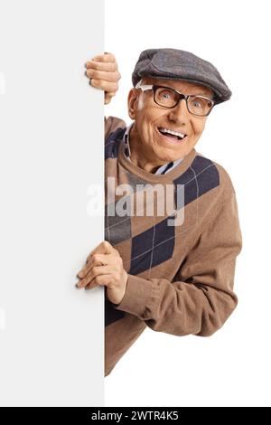 Homme âgé souriant et jetant un œil de derrière un panneau blanc vierge isolé sur fond blanc Banque D'Images