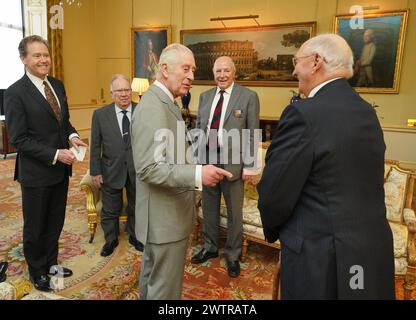 Le roi Charles III (au centre), ainsi que le maître de la maison du roi, le vice-amiral Sir Tony Johnstone-Burt (à gauche), lors d'une audience avec les vétérans de la guerre de Corée (deuxième de gauche à droite) Alan Guy, Mike Mogridge et Brian Parritt, au palais de Buckingham, à Londres. Date de la photo : mardi 19 mars 2024. Banque D'Images