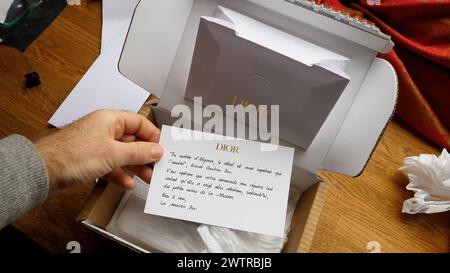 Paris, France - 14 septembre 2023 : une personne déballe un produit Dior avec une note de remerciement, mettant en valeur l’élégance et la marque haut de gamme. Banque D'Images