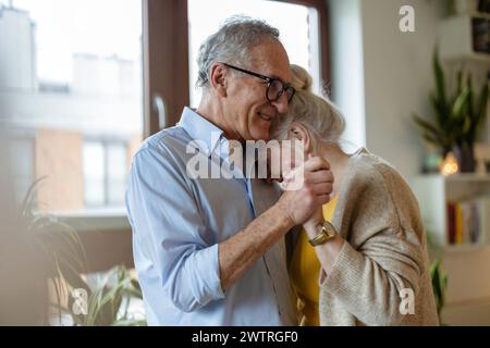 Happy senior couple dancing at home Banque D'Images