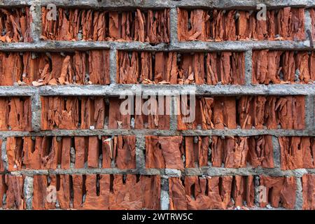 Un mur de briques rouges fissurées du mauvais temps. Vieux murs de briques en ruine d'une vieille maison abandonnée. Banque D'Images