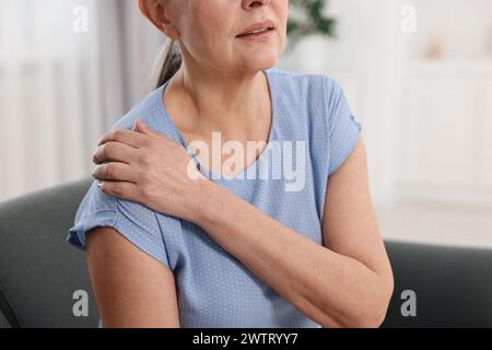 Symptômes de l'arthrite. Femme souffrant de douleurs à l'épaule à la maison Banque D'Images