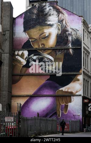 Les gens passent devant une murale intitulée "Honey, I Shrunk the kids" sur le côté d'un bâtiment dans le centre-ville de Glasgow. Peint par l'artiste 'Smug' (Sam Bates). Banque D'Images