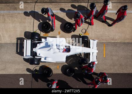 L'équipe au pit est parfaitement synchronisée lors d'un arrêt au pit à grande vitesse. Banque D'Images