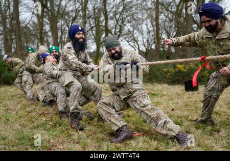 Les soldats sikhs de l'armée britannique concourent dans une lutte contre la guerre alors qu'ils participent au festival militaire Sikh Holla Mahalla, à la garnison d'Aldershot, dans le Hampshire. Le festival Hola Mahalla, vieux de plusieurs siècles, célèbre les traditions martiales sikhs et promeut le courage, la préparation et la préparation. Date de la photo : mardi 19 mars 2024. Banque D'Images