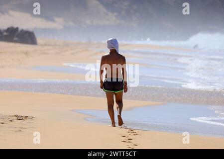 Homme solitaire marchant le long de la plage Playa Piedra, El Cotillo, Fuerteventura, Îles Canaries, Espagne. Banque D'Images