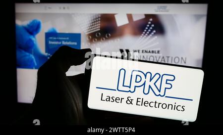 Personne tenant un smartphone avec le logo de la société de technologie allemande LPKF laser Electronics se en face du site Web. Concentrez-vous sur l'affichage du téléphone. Banque D'Images