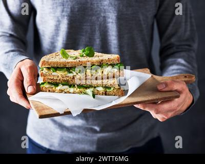 Une personne tenant un sandwich au poulet frais Banque D'Images