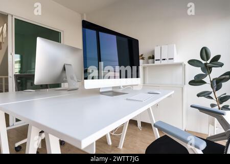 Table blanche et chaise avec écran d'ordinateur et classeur moderne dans l'intérieur blanc du bureau à domicile Banque D'Images