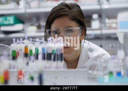 Une scientifique attirante examine un tube à essai pour obtenir des résultats Banque D'Images