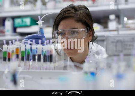 Une scientifique attirante examine un tube à essai pour obtenir des résultats Banque D'Images