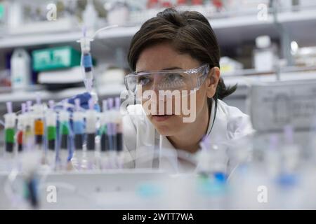 Une scientifique attirante examine un tube à essai pour obtenir des résultats Banque D'Images