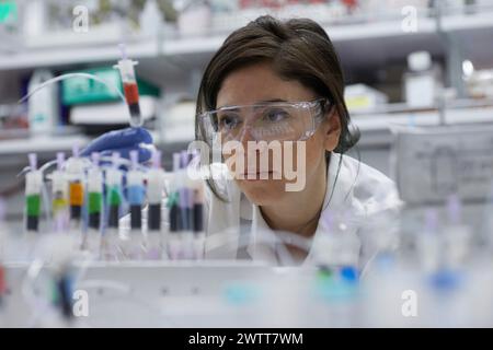 Une scientifique attirante examine un tube à essai pour obtenir des résultats Banque D'Images