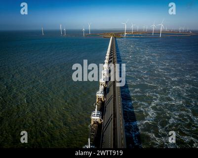 Vue aérienne d'un pont sur l'eau avec des éoliennes. Banque D'Images