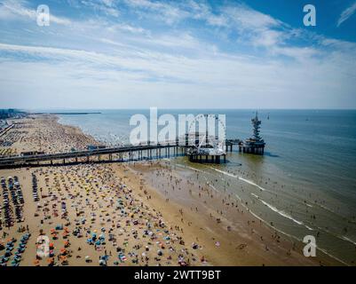 Une journée de plage animée avec une vue panoramique sur une jetée et une grande roue Banque D'Images