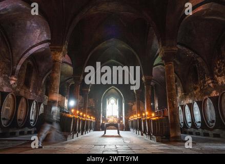 Eltville, Allemagne. 19 mars 2024. Des bougies illuminent les tonneaux de vin dans la cave dite «de l'hôpital» du monastère d'Eberbach. À l'intérieur du complexe monastère vieux de plus de 800 ans, les températures ne fluctuent guère tout au long de l'année. Crédit : Boris Roessler/dpa/Alamy Live News Banque D'Images