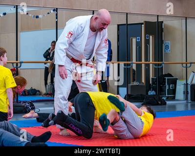 Winchburgh Academy, West Lothian, Écosse, Royaume-Uni, 19 mars 2024. Festival Parasport pour les enfants handicapés : Scottish Disability Sport organise une série de manifestations à l'échelle nationale pour offrir aux jeunes handicapés physiques, malentendants et malvoyants la possibilité d'essayer un large éventail de sports dispensés par des entraîneurs qualifiés locaux. Photo : enfants dans une séance de judo. Crédit : Sally Anderson/Alamy Live News Banque D'Images