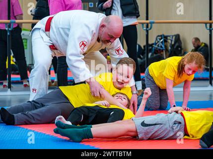 Winchburgh Academy, West Lothian, Écosse, Royaume-Uni, 19 mars 2024. Festival Parasport pour les enfants handicapés : Scottish Disability Sport organise une série de manifestations à l'échelle nationale pour offrir aux jeunes handicapés physiques, malentendants et malvoyants la possibilité d'essayer un large éventail de sports dispensés par des entraîneurs qualifiés locaux. Photo : enfants dans une séance de judo. Crédit : Sally Anderson/Alamy Live News Banque D'Images