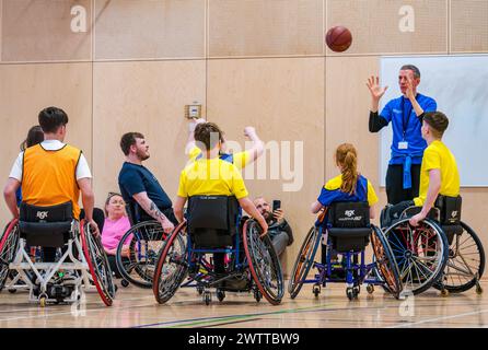 Winchburgh Academy, West Lothian, Écosse, Royaume-Uni, 19 mars 2024. Festival Parasport pour les enfants handicapés : Scottish Disability Sport organise une série de manifestations à l'échelle nationale pour offrir aux jeunes handicapés physiques, malentendants et malvoyants la possibilité d'essayer un large éventail de sports dispensés par des entraîneurs qualifiés locaux. Photo : les enfants essaient le basketball en fauteuil roulant même s'ils n'utilisent pas de fauteuil roulant. Crédit : Sally Anderson/Alamy Live News Banque D'Images