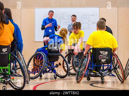 Winchburgh Academy, West Lothian, Écosse, Royaume-Uni, 19 mars 2024. Festival Parasport pour les enfants handicapés : Scottish Disability Sport organise une série de manifestations à l'échelle nationale pour offrir aux jeunes handicapés physiques, malentendants et malvoyants la possibilité d'essayer un large éventail de sports dispensés par des entraîneurs qualifiés locaux. Photo : les enfants essaient le basketball en fauteuil roulant même s'ils n'utilisent pas de fauteuil roulant. Crédit : Sally Anderson/Alamy Live News Banque D'Images