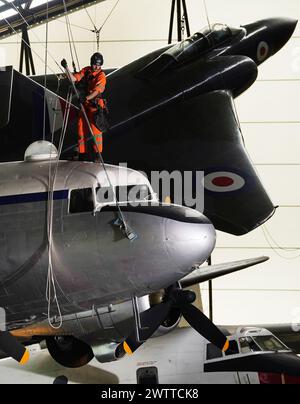 Les spécialistes industriels de l'accès par câble descendent en rappel au Royal Air Force Museum Midlands, à Cosford, près de Telford, Shropshire, pour accéder à une exposition d'avions suspendus exposée à la National Cold War Exhibition, lors du nettoyage et de la maintenance annuels des avions de haut niveau. Date de la photo : mardi 19 mars 2024. Banque D'Images