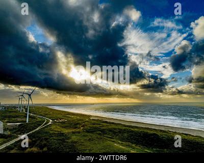 Ciel spectaculaire au-dessus d'un parc éolien côtier au coucher du soleil Banque D'Images