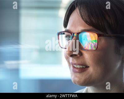 Femmes professionnelles concevant un diagramme circulaire sur un ordinateur pour illustrer les statistiques d'entreprise. Banque D'Images