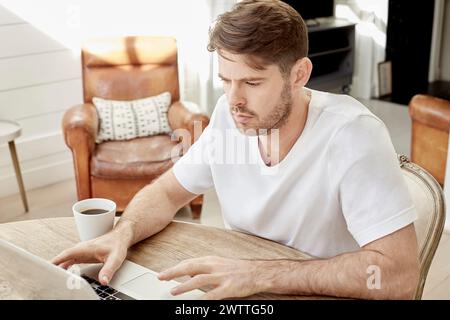 L'homme travaillant sur un ordinateur portable à la maison Banque D'Images
