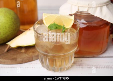 Savoureux kombucha et glaçons en verre sur une table en bois blanc, gros plan Banque D'Images