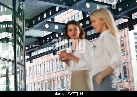 Deux femmes ayant une conversation dans un bureau moderne Banque D'Images