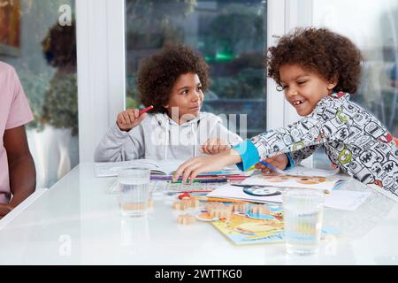 Deux enfants appréciant des activités de coloriage à une table. Banque D'Images